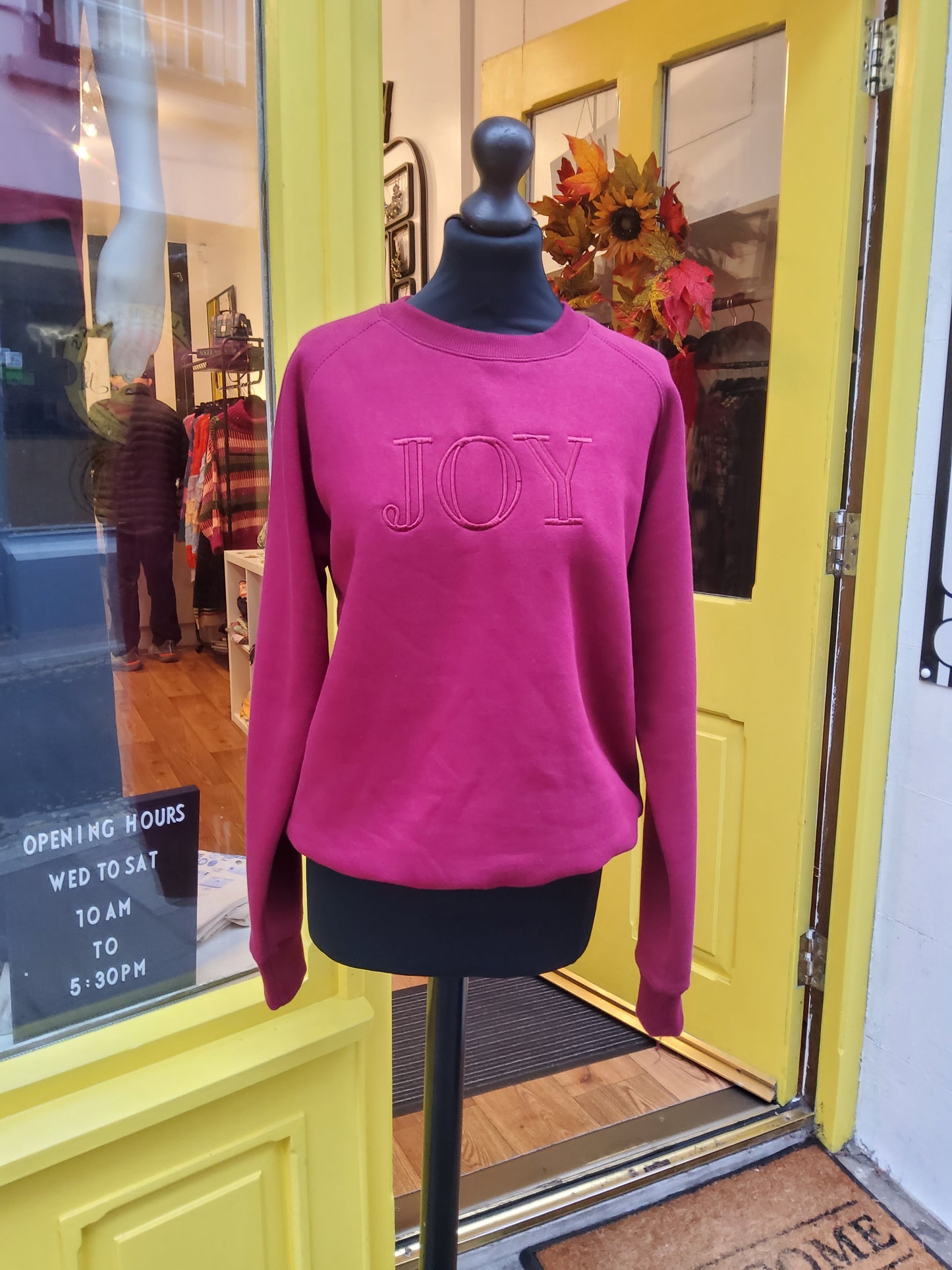 Burgundy sweatshirt with 'JOY' embroidered on front